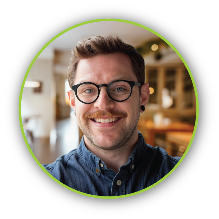 Professional Headshot of Graham Hennessy - Hookd Promotions Team Graham Hennessy smiling in a modern office setting, wearing glasses and a blue button-down shirt